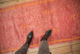 Vintage Moroccan runner with textured faded cherry red pile and tangerine geometric details.