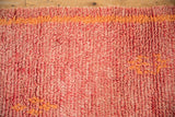 Hand-knotted pile texture of a vintage Moroccan runner in faded cherry red and tangerine orange.