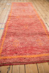 Faded cherry red pile of vintage Moroccan runner with tangerine geometric accents and border.