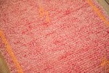 Faded raspberry red hand-knotted pile with pale tangerine orange geometric accents.