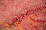 Shaggy pile texture of vintage Moroccan rug runner with faded cherry red and pale tangerine.
