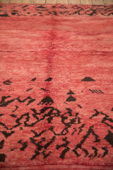 Plush raspberry red pile with dark chocolate brown abstract patterns on a vintage Moroccan rug.