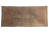 Distressed vintage Bibikabad carpet featuring a multi-medallion Herati design in faded navy and blush.