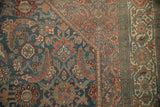 Distressed vintage Bibikabad rug corner with Herati design in dusty navy, blush, and faint foundation.