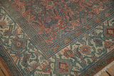 Corner of distressed Bibikabad carpet, featuring intricate borders, faded Herati pattern, and visible wear.