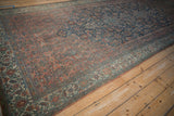Distressed vintage Bibikabad carpet corner, dusty blush Herati motifs, intricate blue ivory border.