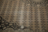 Distressed Sivas carpet with pale coffee brown field, dark charcoal cartouches, and arabesque spandrel.
