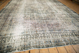 Corner of distressed Bibikabad rug with prominent navy, ivory crab style border.