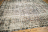 Storied texture of a distressed Bibikabad carpet, with faded navy, ivory, and subtle Herati pattern.