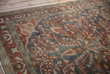 Distressed Lilihan carpet detail showing muted burgundy and charcoal floral motifs with even wear.