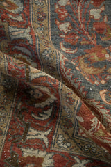 Distressed pile of the vintage Lilihan carpet, showing deep burgundy and charcoal tones.