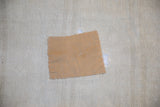 Textured beige hemp rug with a light brown applied patch and white stitching.