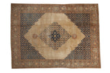Vintage distressed Tabriz carpet with a scalloped medallion, navy blue spandrels, and a pale camel field.