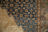 Sharp serrated navy spandrel with Herati designs on a distressed vintage Tabriz rug.