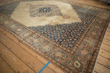 Sharp serrated navy spandrel contrasts with the distressed camel field of a vintage Tabriz carpet.
