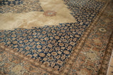 Sharp serrated navy spandrel with Herati motifs on a distressed pale camel vintage Tabriz rug.