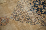Worn texture on a vintage Tabriz carpet's scalloped medallion and Herati pattern detail.