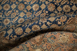 Textured weave of a draped, distressed Tabriz carpet showing contrasting navy and camel patterns.