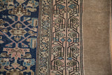 Antique Persian runner's blush border with meandering vine motifs and chocolate brown selvage.