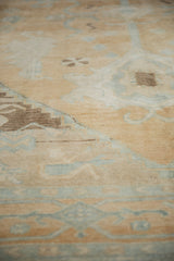 Textured pile of the distressed vintage Oushak rug in sand, ivory, and soft blue.