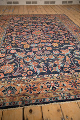 Persian Dargezine carpet detail: navy field with red, blue, and blush floral arabesques.