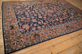 Dargezine carpet's intricate floral blossoms, arabesques, and pearled leaves in navy and copper.