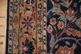 Vintage Dargezine carpet close-up with floral arabesques, brick red and navy blue tones, and secured selvage.