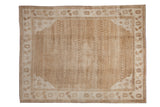 Vintage Kars carpet with a distressed low pile, a subtle lattice pattern, and a floral border in warm sand and beige.