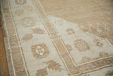 Intact side cord selvage and floral border on a short-pile Kars rug in sand tones.