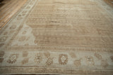 Angled perspective of a vintage Kars rug's textured field and floral border in soft neutral tones.