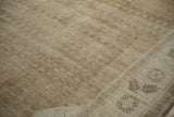 Distressed Kars carpet showing low pile texture, abrashes, and a simple finned fern leaf border.