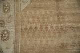 Short pile texture on a distressed Kars rug with lattice vines and a floral border in soft beige tones.