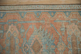 Distressed Hamadan rug detail: cantaloupe, blue floral pattern, worn pile, exposed foundation.