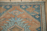 Distressed vintage Hamadan runner corner, cantaloupe and blue floral motifs, with meandering vine border.