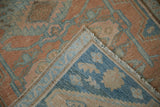 Secured end, woven foundation, and worn pile of a vintage distressed Hamadan rug.