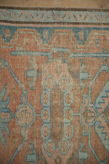 Distressed Hamadan rug with cantaloupe melon and dusty blue floral cross-section medallion.