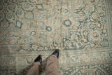 Distressed vintage Khorassan rug with faded teal and sand floral patterns underfoot.