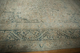 Distressed wide border of the vintage Khorassan rug with meandering vines and faded teal.
