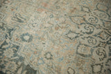 Distressed texture of vintage Khorassan carpet, highlighting faded floral vines in sand and dusty teal.