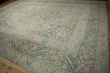 Distressed vintage Khorassan border showcasing meandering vines and faded teal floral arabesques.