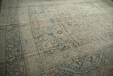 Decorative worn texture of a distressed Khorassan carpet, highlighting faded teal and sand floral patterns.