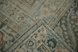 Folded vintage distressed Khorassan carpet corner, revealing worn pile, foundation, and teal blue border.
