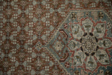Worn knot heads detail the texture of a Malayer rug's Samovar border and rust-red field.
