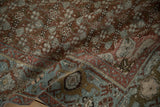 The distressed, hand-knotted texture of an antique Malayer rug's turtle Samovar border.
