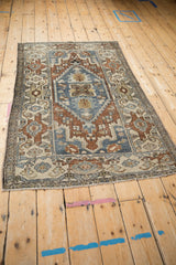 Distressed vintage Hamadan rug corner with soft fringe and geometric ivory, blue border.