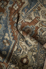 Close-up of distressed Hamadan rug: worn pile, geometric patterns in blue, brown, and ivory.