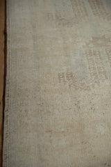 Secured side selvage and worn pile texture of distressed Oushak rug, ivory and sand tones.