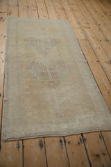 Distressed vintage Oushak rug showing even pile wear and intact side selvage.