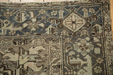 Vintage Distressed Mehrivan carpet corner with dusty teal, brown, ivory geometric patterns and visible wear.