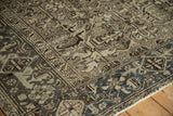 Vintage distressed Mehrivan rug corner, dusty teal border framing chocolate brown floral patterns.